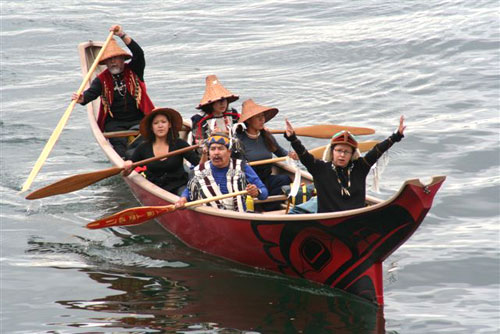 Indigenous peoples rowing in a canoe