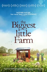 cover of the DVD film The Biggest Little Farm shows the backs of a man and woman walking through a farm field. A dog, two highland cows and chickens next to a red chicken coop.