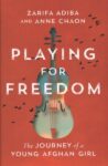 Book cover of Playing for Freedom: the journey of a young Afghan girl by Zarifa Adiba and Anne Chaon shows a violin with tiny black birds flying across the book cover against a red background.