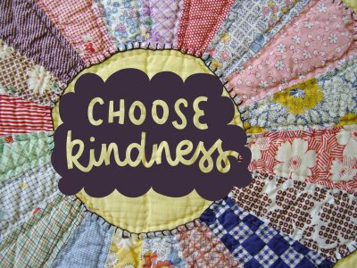 Close up image of a patchwork quilt with the words Choose Kindness n the middle of it.